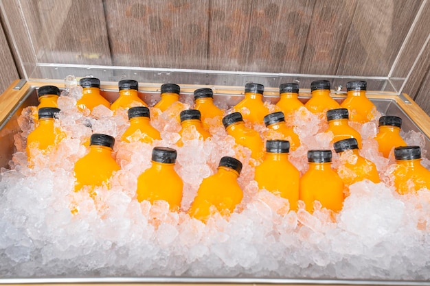 Essen und trinken Sie Orangensaft in einer Flasche mit Eis