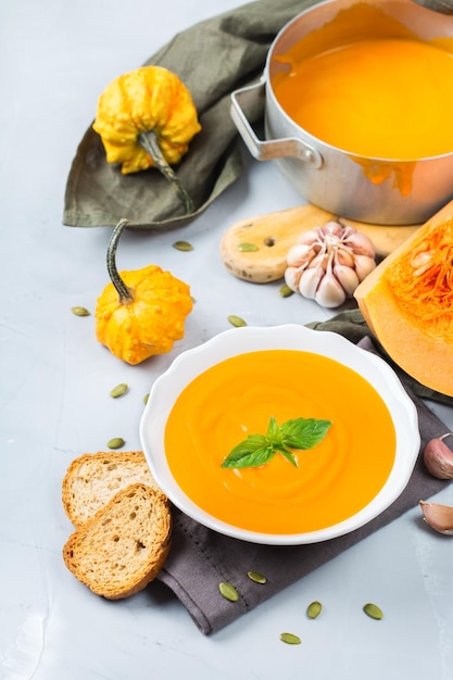 Essen und Trinken Stillleben Diät- und Ernährungskonzept Saisonale Herbst Herbst geröstete orangefarbene Kürbis-Karottensuppe mit Zutaten auf einem Tisch