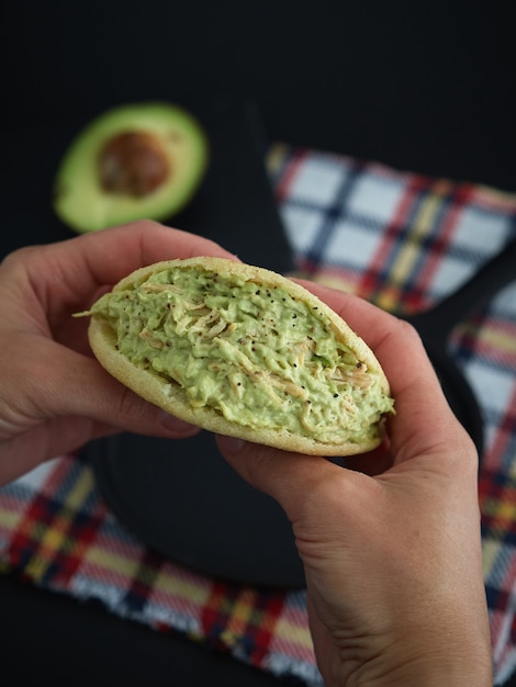 Essen venezolanische Arepa Reina Pepiada mit dunklem Hintergrund