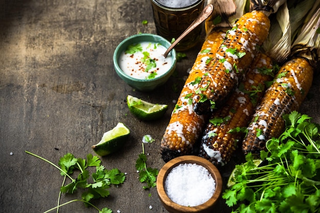 Essen von gegrillten Maiskolben mit frischem Kräuterlimebier und Salsa