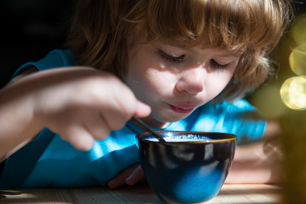 Essen zu hause für kinder gesunde gewohnheiten junge isst frühstück in der küche kinderernährung