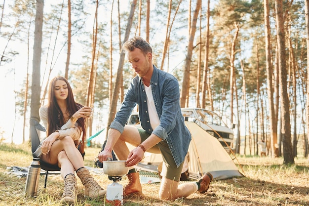 Essen zubereiten Junges Paar ist tagsüber gemeinsam im Wald unterwegs