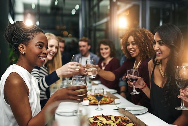 Essensparty und Wein mit Freunden im Restaurant für feierliche Pizza und gesellschaftliche Veranstaltungen Fröhliche Vielfalt und Toast mit einer Gruppe von Menschen, die zusammen essen, um gutes Essen zu genießen und Freizeit zu haben