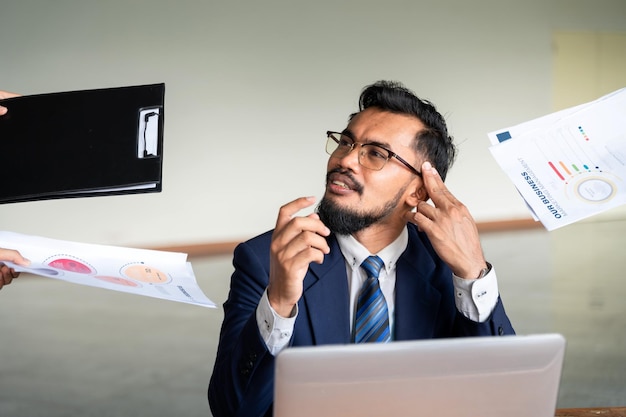 Esses prazos estão me esgotando A imagem de um jovem empresário está ansioso em sua mesa no escritório