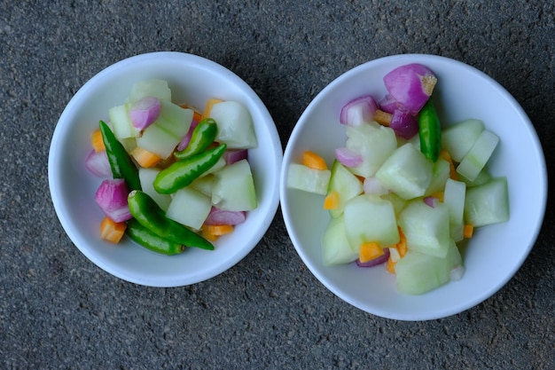 Essiggurke, Karotte, Zwiebel, Karotte und grüner Cayennepfeffer in einer Keramikschale. Asiatisches Gericht