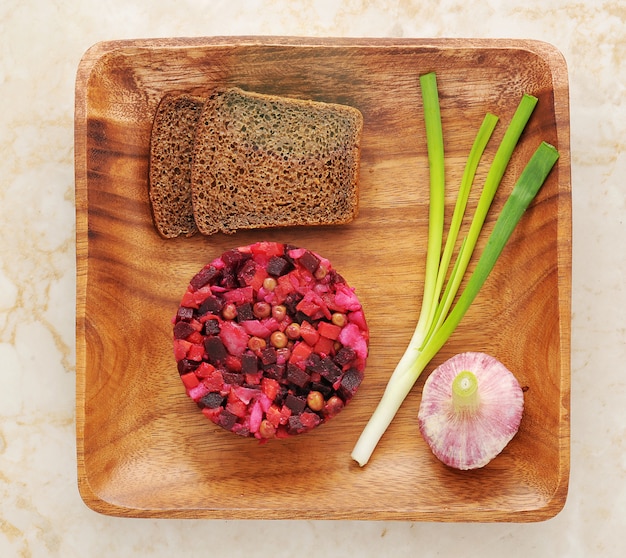 Essigsoße auf hölzerner Platte mit Roggenbrot und Frühlingszwiebeln