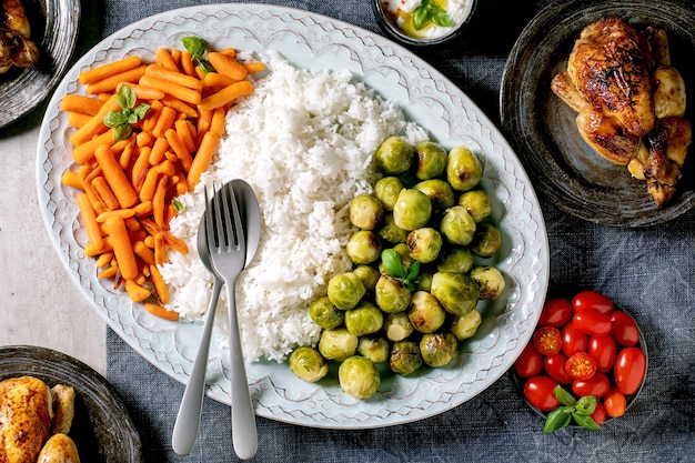 Esstisch mit gegrilltem Hähnchen, Reis und Gemüse