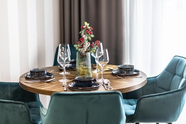 Esszimmer mit Holztisch und blauen Stühlen in einem modernen Apartment. Modernes Ambiente im Essbereich des Apartments