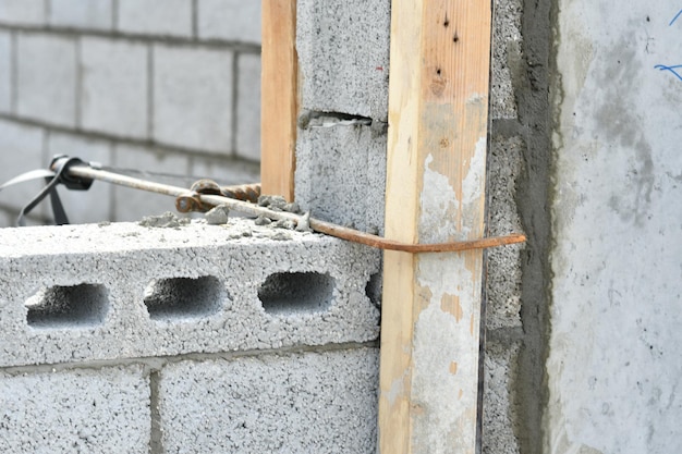 Se está construyendo una pared de ladrillos con una barra de soporte de madera.