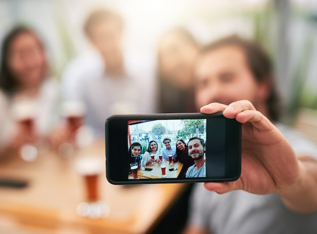 Esta foto está subindo nas mídias sociais Foto de um grupo jovem e alegre de colegas de trabalho tirando um auto-retrato juntos em um restaurante