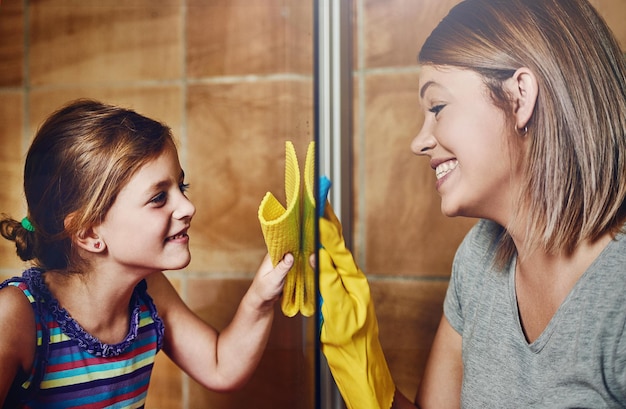 Está limpio solo una vez que podemos vernos claramente Captura recortada de una madre y su pequeña hija limpiando juntas un baño en casa