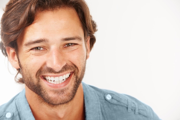 Está lleno de positividad Un hombre guapo sonriendo contra un fondo blanco