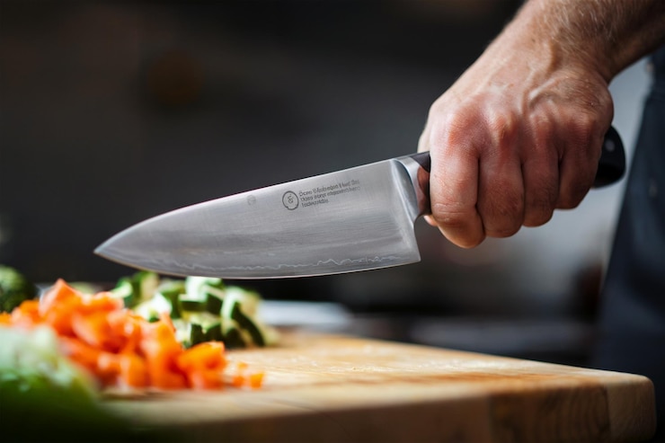 Foto se está usando un cuchillo para cortar verduras en una tabla de cortar