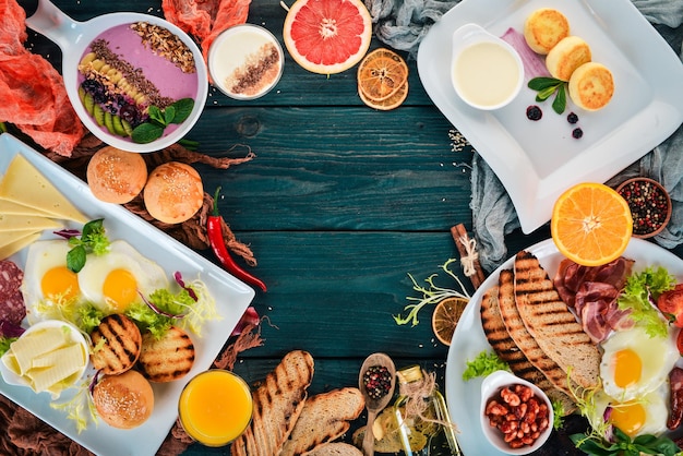 Establecer desayuno Huevos yogur frutas queso Vista superior Sobre un fondo de madera Copiar espacio