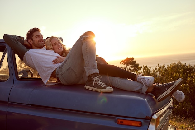 Establecer un poco de amor Foto de una joven pareja cariñosa en un viaje por carretera