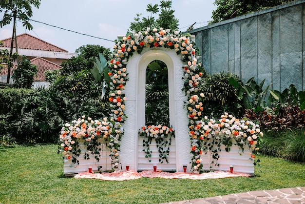 Establecimiento de la ceremonia de bodas al aire libre con una decoración elegante con cortinas blancas arreglos florales altar