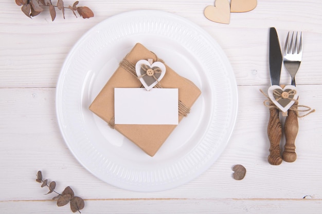 Foto establecimiento de la mesa del día de san valentín con regalo y tarjeta blanca estilo cero desperdicio