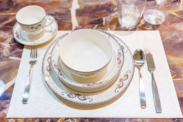 Establecimiento de la mesa en la mesa de comedor de madera en el hogar