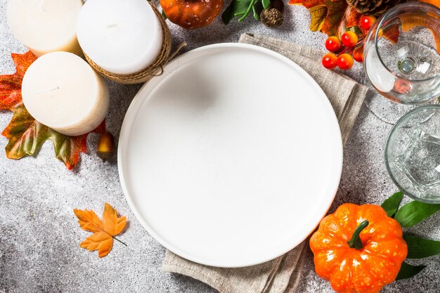 Establecimiento de mesa de otoño con velas blancas y decoraciones de otoño