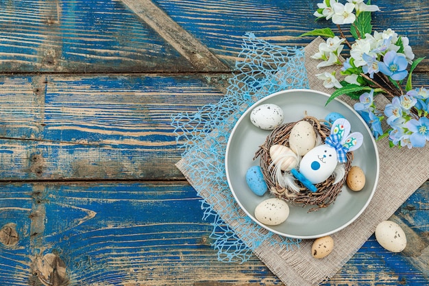 Establecimiento de la mesa de Pascua con huevos nido de pájaro y rama en flor