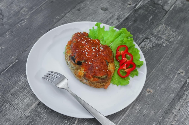 Estaca de carne frita sob queijo com legumes na chapa branca