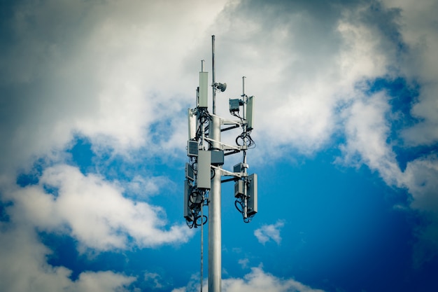 Estação base celular com antenas transmissoras em uma torre de telecomunicações