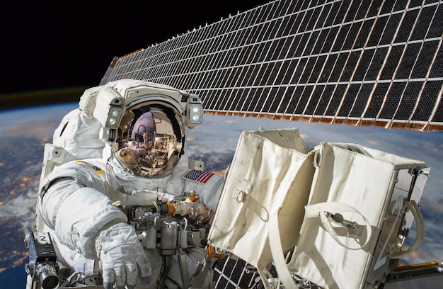 Estação Espacial Internacional e astronauta no espaço sideral sobre o planeta Terra. Elementos desta imagem fornecidos pela NASA.