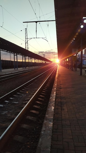 Estação ferroviária no fundo de um pôr do sol ensolarado