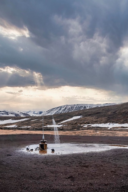 Estación de ducha caliente al aire libre de energía geotérmica en krafla contra cloudscape