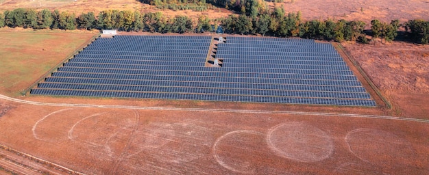 Estación de energía solar en campo con hierba quemada por el sol