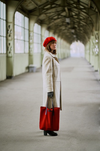 Estación de ferrocarril. Hermosa chica está esperando el tren. La mujer viaja ligera. Dama de mediana edad