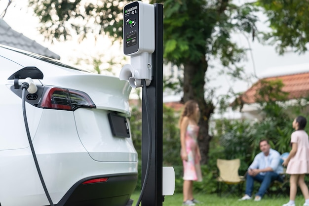 La estación de recarga de baterías de EV para el coche EV en los sincronismos familiares borrosos