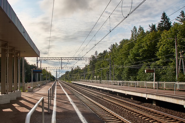 estación de tren suburbano con rieles y plataformas en dos direcciones