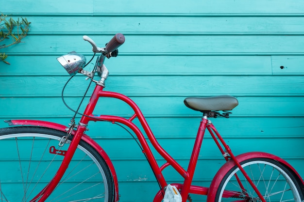 Estacionamento bicyle vintage vermelho na parede de madeira azul