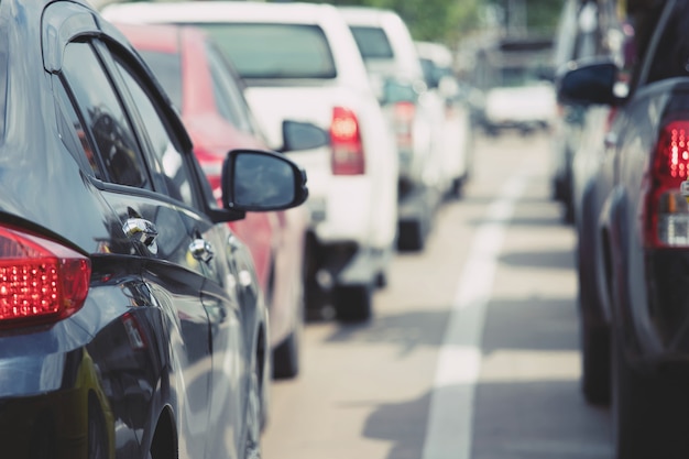 Foto estacionamiento aéreo al aire libre, autos traseros en fila estacionamiento al costado de la carretera.