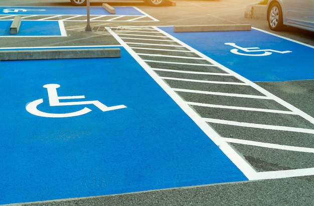 Foto estacionamiento de asfalto reservado para conductores discapacitados en supermercado o centro comercial. plaza de aparcamiento para minusválidos. pintura de signo de silla de ruedas en el área de estacionamiento de asfalto. estacionamiento para discapacitados.