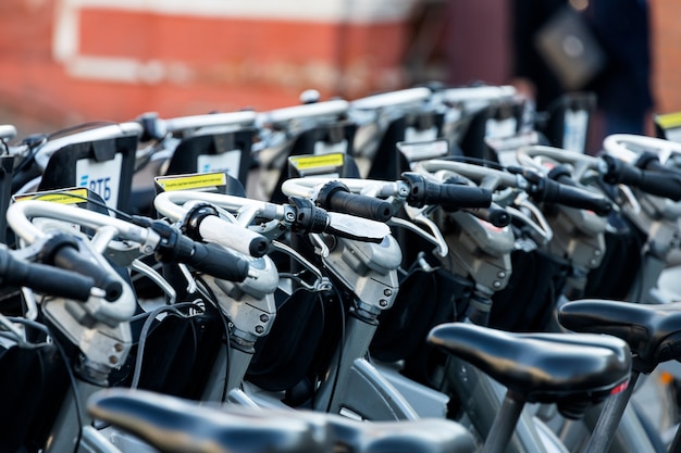 Estacionamiento en la calle con bicicletas para alquilar bajo el sol brillante