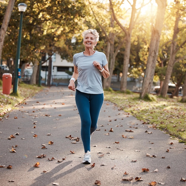 Estacione a corrida e a forma física com uma mulher idosa ao ar livre para treinamento cardiovascular ou de resistência no verão Exercício esportivo e saúde com uma aposentada madura do lado de fora para uma corrida durante a aposentadoria