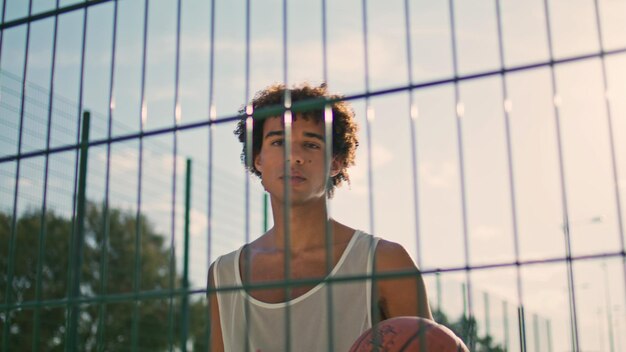 Estádio de treinamento de jogador de basquete diminuir o zoom homem de cabelo encaracolado jogando posando