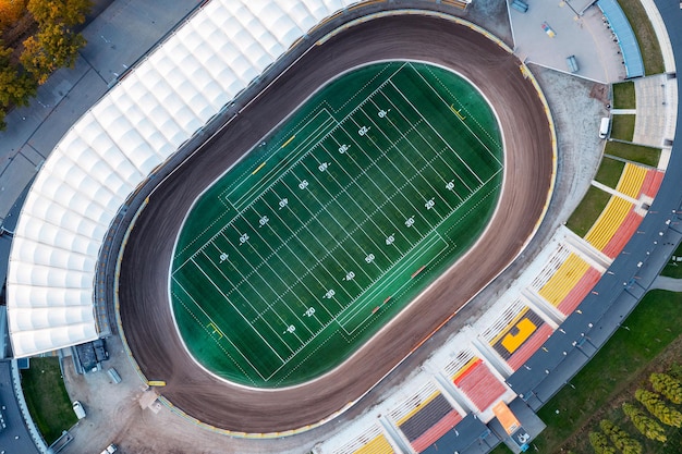 Estadio de fútbol con césped verde brillante y marcas de líneas blancas. Fútbol americano. Vista desde arriba