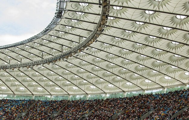 Foto estadio de fútbol dentro de vista campo de fútbol vacío se encuentra una multitud de aficionados un techo contra el cielo