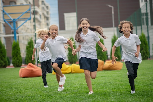 Estado de ánimo activo. Grupo de niños corriendo y mirando feliz