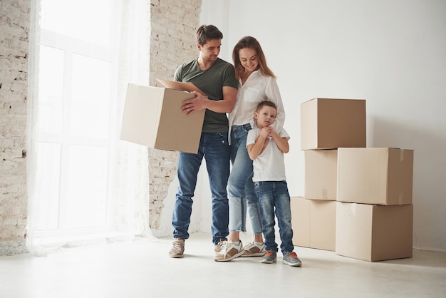 Estado de ánimo juguetón del niño. La familia tiene mudanza a casa nueva. Desembalaje de cajas de mudanza.