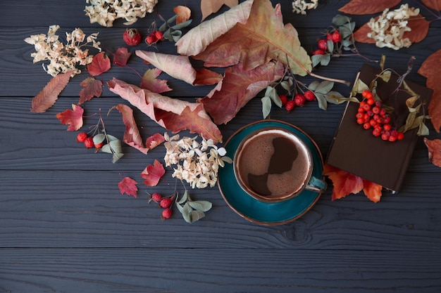 Estado de ánimo otoñal una taza de café entre hojas de otoño en una mesa oscura de madera con espacio para copiar Vista superior