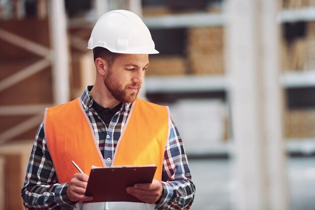 Estado de ánimo positivo Empleado en uniforme está trabajando en el almacenamiento durante el día