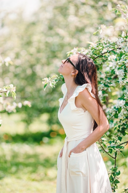 Estado de ánimo de primavera hermosa mujer olor a árbol floreciente disfrutando de la naturaleza jardín floral blanco