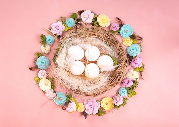 Estado de ánimo primaveral, decoración de huevos de Pascua, flores de papel, una guirnalda de enredaderas sobre un fondo de coral vivo.