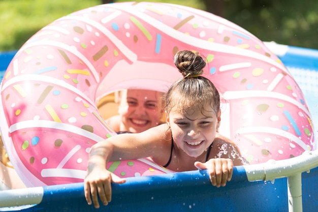 Estado de natação em mente. Crianças felizes nadam na bóia de piscina de donuts. Dia de piscina gelada. Férias de verão