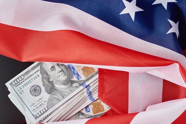 Estados Unidos bandera nacional y billetes de dólar en la oscuridad. Concepto de finanzas