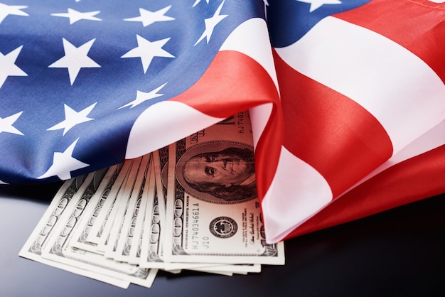 Estados Unidos bandera nacional y moneda usd dinero billetes en una oscuridad. Negocios y Finanzas